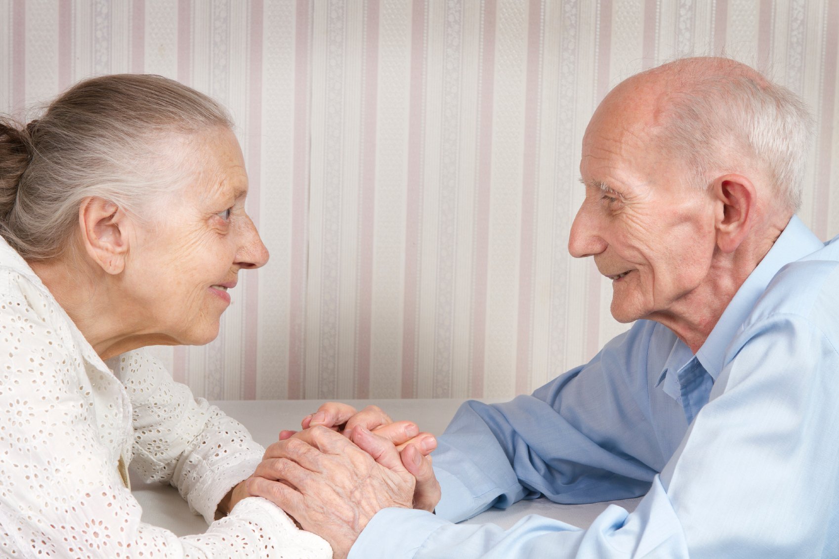Oudere meneer en mevrouw kijken elkaar liefdevol aan