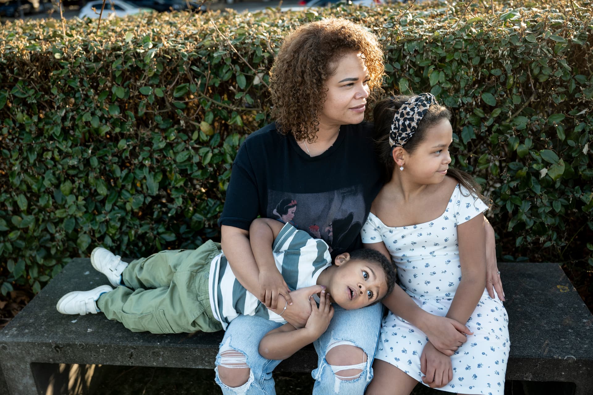 Moeder met twee kinderen buiten op een bankje